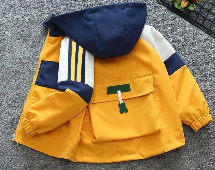 Yellow children's jacket with navy and white accents on a gray surface