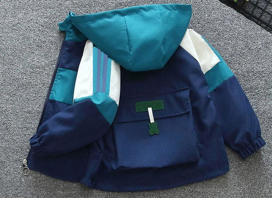Blue and green jacket with a hood on a gray surface